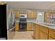 Spacious kitchen featuring stainless steel refrigerator, wooden cabinets, black appliances, and double sink at 2020 Moore Rd, Moreland, GA 30259