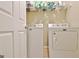 Practical laundry room with white washer and dryer units, storage shelves, and a clean, functional design at 2020 Moore Rd, Moreland, GA 30259