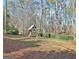 Backyard featuring a colorful wooden playground and set surrounded by trees and fallen leaves at 232 Terrane Rdg, Peachtree City, GA 30269