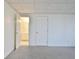 A bedroom with carpet has a door that is opened to reveal a bathroom with a mirror and a white vanity at 232 Terrane Rdg, Peachtree City, GA 30269