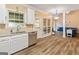 Well-lit kitchen featuring white cabinets, stainless steel appliances, and wood flooring at 232 Terrane Rdg, Peachtree City, GA 30269