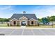 View of the community clubhouse, pool and playground with parking lot in front and landscaping at 1715 Goodwin Dr, Hampton, GA 30228
