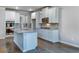 Bright kitchen features white cabinets, stainless steel appliances, gray countertops, backsplash, and dark wood floors at 659 Edgar Dr, Hampton, GA 30228