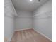 Empty walk-in closet is equipped with adjustable white wire shelving and neutral walls and carpet at 659 Edgar Dr, Hampton, GA 30228