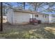 Backyard with a door to the house, a small deck with stairs, and a mix of grass and fallen leaves at 1471 Cedar Creek Ln, Riverdale, GA 30296