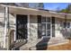 Inviting front porch with a black front door, shuttered window, and classic exterior at 1471 Cedar Creek Ln, Riverdale, GA 30296