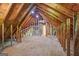 Bright, unfinished attic space with exposed beams and plywood flooring, offering potential for customization and expansion at 65 Riverside Way, Sharpsburg, GA 30277