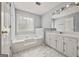 Bright bathroom featuring a soaking tub, vanity with a sink, and marble tile flooring at 65 Riverside Way, Sharpsburg, GA 30277
