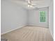 Comfortable bedroom featuring a ceiling fan, neutral carpet, and bright windows at 65 Riverside Way, Sharpsburg, GA 30277