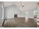 Spacious living room boasts vaulted ceilings, a stone fireplace, and modern gray wood flooring at 65 Riverside Way, Sharpsburg, GA 30277