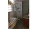 Bathroom featuring a tile-surround tub, glass shower, and single sink vanity at 138 Le Brun Ne Rd, Atlanta, GA 30342