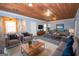 Finished basement living area with wood ceiling, stylish furniture, and a large TV at 568 Martin Mill Rd, Moreland, GA 30259