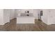 Open kitchen with island, stainless steel appliances, and hardwood floors at 11996 Conrad Cir # 128, Hampton, GA 30228