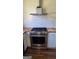 Kitchen with stainless steel stove and hood, subway tile backsplash, and butcher block countertops at 1839 Lakewood Se Ave, Atlanta, GA 30315