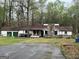 Ranch home featuring brick fireplace, two-car garage, and mature trees at 2497 Old Jackson Rd, Locust Grove, GA 30248