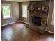 A living room with a stone fireplace with two windows on either side to provide ample natural lighting at 2497 Old Jackson Rd, Locust Grove, GA 30248