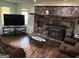 Cozy living room with a stone fireplace, hardwood floors, and large windows providing natural light at 2497 Old Jackson Rd, Locust Grove, GA 30248
