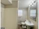 Cozy bathroom featuring a pedestal sink, toilet, and shower with beige tile accents at 422 Windsor Dr, Forest Park, GA 30297