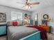 Cozy bedroom featuring a ceiling fan, light gray walls and carpet, and a colorful turquoise bed frame at 950 Old Jackson Rd, Locust Grove, GA 30248