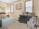 Bedroom featuring tan walls, two windows, a black dresser, a decorative chair, and a bed to the left at 950 Old Jackson Rd, Locust Grove, GA 30248