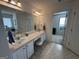 Well-lit main bathroom featuring double sinks, vanity, and separate tub and shower areas at 3129 Oak Ridge Ln, Loganville, GA 30052