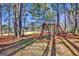 Backyard with wooden swing set and trees, view of golf course at 102 Morallion Hls, Peachtree City, GA 30269