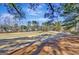 Backyard view of a golf course and homes through trees at 102 Morallion Hls, Peachtree City, GA 30269