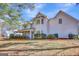 Side view of a two-story home with white siding, screened porch, and landscaping at 102 Morallion Hls, Peachtree City, GA 30269