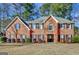 Brick two-story house with a large front yard and mature trees at 102 Morallion Hls, Peachtree City, GA 30269