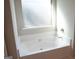 Clean white bathtub with chrome fixtures and a window for natural light at 12226 Flannery Ln, Hampton, GA 30228