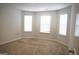 Well-lit bedroom featuring three windows and plush carpeting for comfort at 12226 Flannery Ln, Hampton, GA 30228