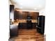 Modern kitchen featuring dark wood cabinets, granite countertops, and black appliances at 12226 Flannery Ln, Hampton, GA 30228