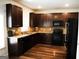 Modern kitchen featuring dark wood cabinets, granite countertops, and black appliances at 12226 Flannery Ln, Hampton, GA 30228