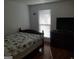 Cozy bedroom featuring wood floors, a queen-sized bed, and natural light from a window at 3248 Brisbane Way, Lithonia, GA 30038