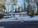 Ranch style home with snow covered yard and trees at 3248 Brisbane Way, Lithonia, GA 30038