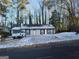 Ranch style home with snow covered yard and trees at 3248 Brisbane Way, Lithonia, GA 30038