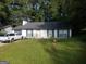 Charming single-story home featuring a well-maintained lawn, grey paint, and dark shutters at 3248 Brisbane Way, Lithonia, GA 30038