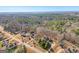 Aerial view of house and surrounding neighborhood, showcasing wooded area and quiet street at 811 Somersby Dr, Dallas, GA 30157