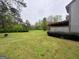 Large backyard with a sprawling green lawn, mature trees, and natural landscaping at 97 Willowick Dr, Lithonia, GA 30038