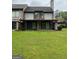 Spacious backyard with lush green grass, and a covered porch at 97 Willowick Dr, Lithonia, GA 30038
