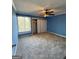 Spacious bedroom features neutral carpet, a ceiling fan, and ample natural light from a window at 97 Willowick Dr, Lithonia, GA 30038