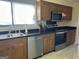 Kitchen featuring wooden cabinetry, stainless steel appliances, and dark countertops at 97 Willowick Dr, Lithonia, GA 30038