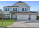 Two-story house with gray siding, brick accents, and a three-car garage at 3560 Summerpoint Xing, Cumming, GA 30028