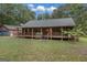 Charming log cabin home with a spacious front porch and detached garage at 184 Elm St, Covington, GA 30014