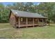 Charming log cabin home with a spacious front porch and detached garage at 184 Elm St, Covington, GA 30014