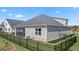 Landscaped backyard with well-manicured lawn, screened porch, black fence, and neighboring houses at 592 Parnassus Rd, Locust Grove, GA 30248