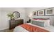 Bedroom with a large dresser, neutral colors, soft lighting, and a large decorative pillow at 592 Parnassus Rd, Locust Grove, GA 30248