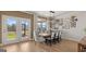 Bright dining room features a modern chandelier, neutral walls, light wood floors and sliding doors to the back porch at 592 Parnassus Rd, Locust Grove, GA 30248