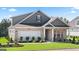 Inviting one-story home featuring gray brick, white trim, and a two-car garage at 592 Parnassus Rd, Locust Grove, GA 30248