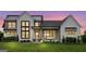 Modern farmhouse exterior at dusk, featuring a metal roof and large windows at 0 Matteo Way # 4, Fayetteville, GA 30215